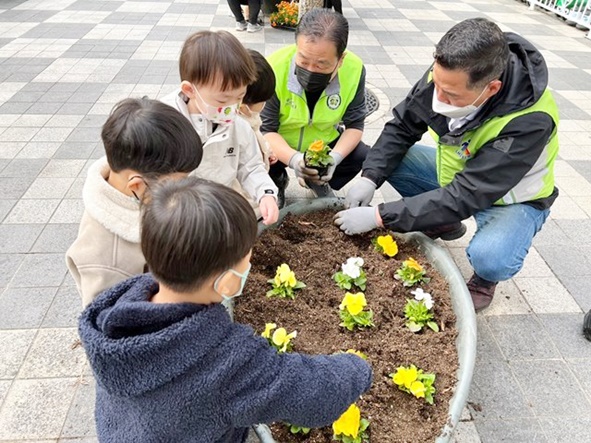 지난 5일 음성신천 휴먼시아아파트 입주민과 어린이집 아이들이 고사리 손으로 꽃모종을 함께 식재하고 있다.