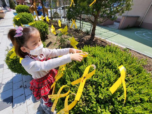 대소유치원 어린이가 세월호 8주기 기념 노란 리본을 달고 있다.