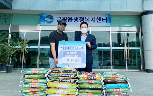 (주)네이쳐팜스 관계자가 금왕읍에 쌀 등을 기탁하며 박제욱 읍장과 기념촬영을 하고 있다.