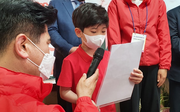 장용식 후보의 아들인 장태휘 군이 아빠를 응원하는 글을 읽고 있다.