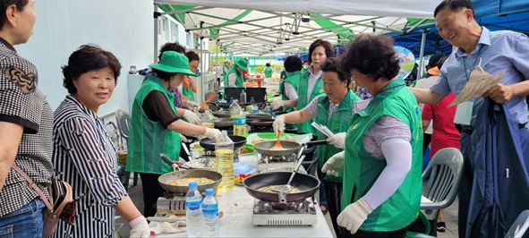 ▲음식을 제공하고 있는 새마을부녀회원들 모습.