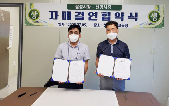 음성전통시장이 전북 군산의 신영시장과 업무협약을 체결하고 양 대표들이 기념촬영을 하고 있다.