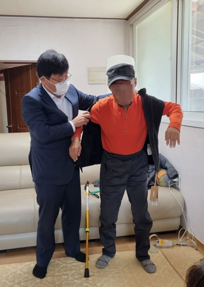 정동혁 대소면장(사진 왼쪽)이 저소득층 주민에게 옷을 지원하고 있다.
