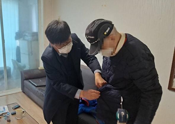 정동혁 대소면장이 독거노인에게 방한복을 입혀드리고 있다.
