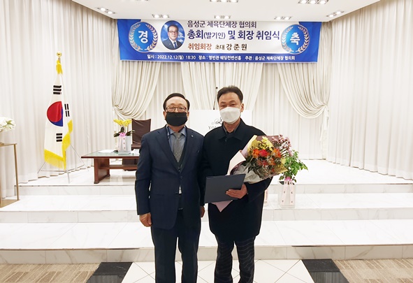 강준원 음성군체육단체장협의회 초대 회장이 이양희 부회장에게 꽃다발을 전달하고 있다.