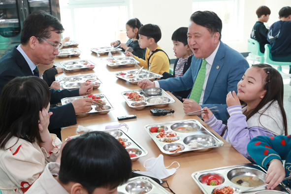 김영환 도지사(사진 오른쪽)와 윤건영 교육감이 단재초 식당에서 어린이들과 함께 식사하며 이야기를 나누고 있다.