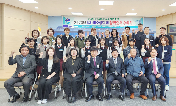 김영호 대소장학회이사장과 회원들이 장학증서를 수여하고 장학생들과 기념촬영을 하고 있다.