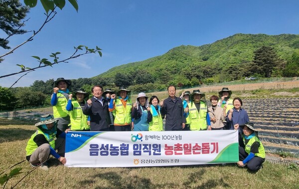 음성농협 직원들이 박노대 조합장과 함께 일손돕기하며 기념촬영을 하고 있다.