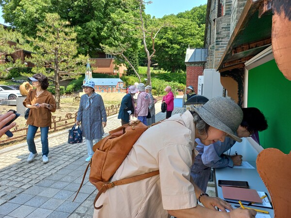 전국에서 모여든 관광객들이 봉헌할 소원의 편지를 쓰고 있는 모습.