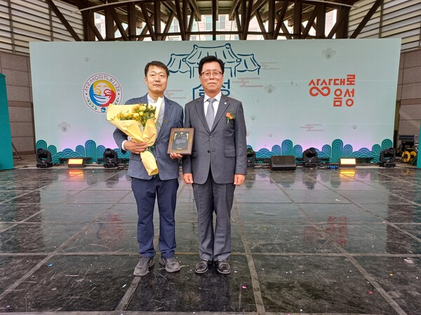김효진 탑이엔씨 대표가 음성군의장 표창 후 안해성 의장과 함께 기념촬영하고 있다.